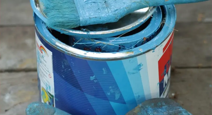 Puszka z niebieską farbą olejną i pędzel. Zastanawiasz się, czym zmyć farbę olejną?