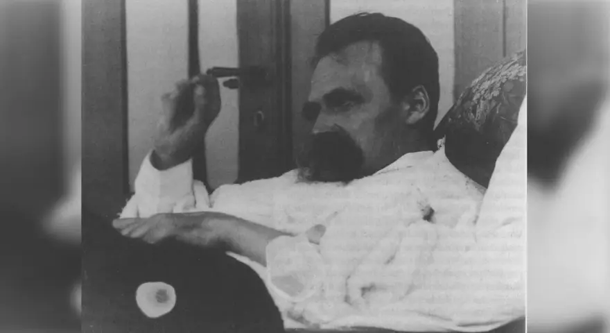 Nietzsche, zamyślony, w białej koszuli, z charakterystycznym wąsem. Jego poglądy kształtują obraz myśli.