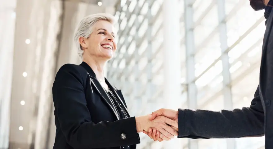 Due professionisti si stringono la mano, un gesto di accordo e fiducia. Sono colleghi raccomandati sul lavoro, pronti a collaborare.