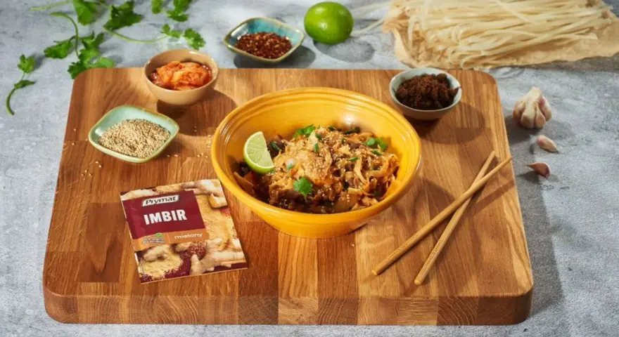Curry z kurczakiem czy stir-fry z wołowiną? Na desce składniki do dania z makaronem ryżowym, imbir, sezam, chili, czosnek i limonka.