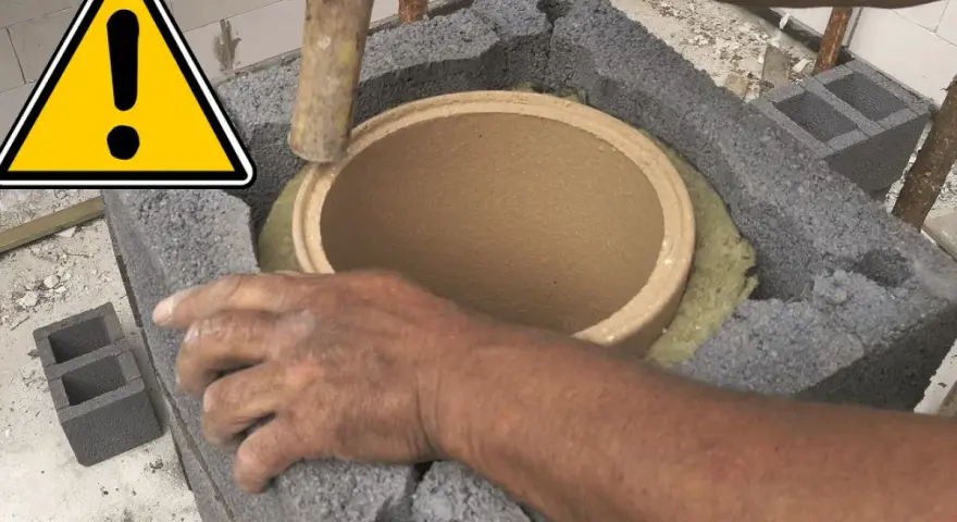Ręce montują ceramiczny czopuch w konstrukcji z pustaków. Ostrzeżenie przed pracami budowlanymi.