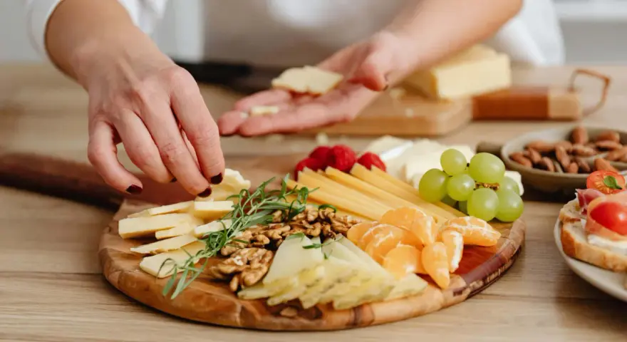 Tabla de quesos variados, frutos secos, uvas y gajos de mandarina, perfecta para unos entrantes saludables.