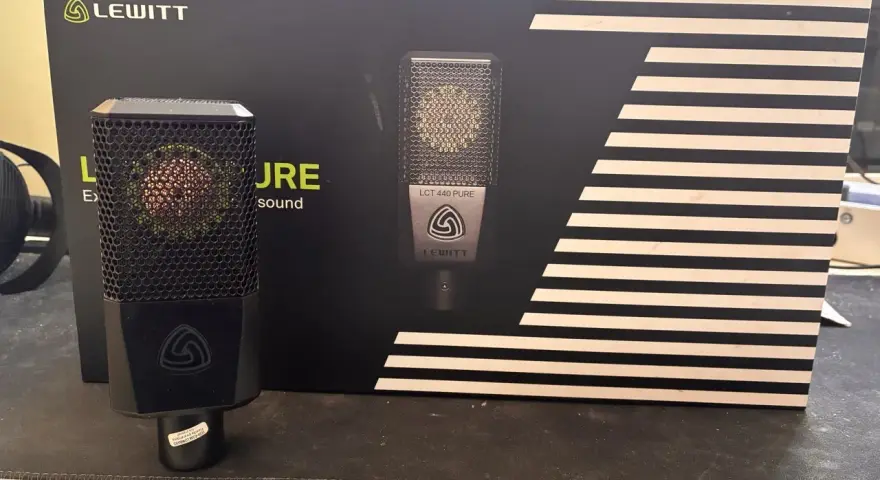 Mikrofon Lewitt LCT 440 PURE na tle czarnego pudełka z białymi paskami.