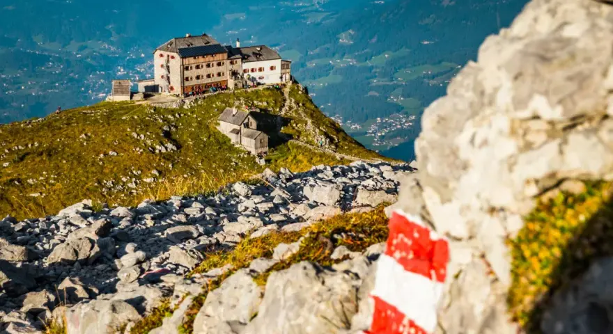 Watzmannhaus Wanderung: Ein markierter Weg führt zu diesem Berggasthof auf einem felsigen Grat mit Blick ins Tal.