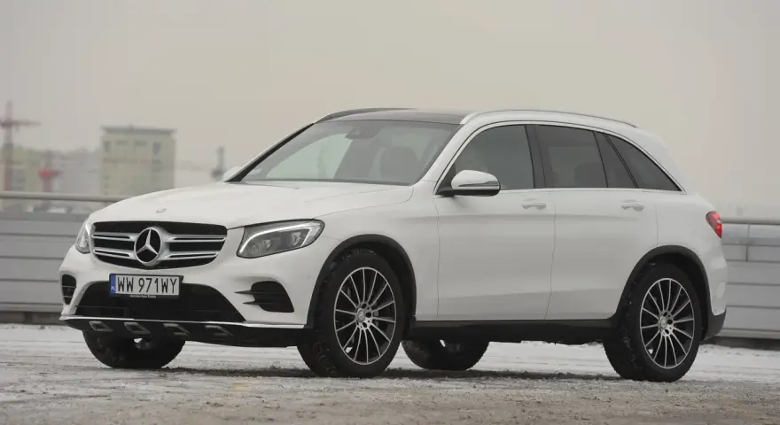 Biały Mercedes GLC 220d na tle miejskiego krajobrazu, gotowy na zimowe wyzwania.