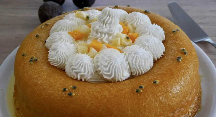 Un baba au rhum doré, garni de crème fouettée, fruits exotiques et graines de fruits de la passion. Un délice !