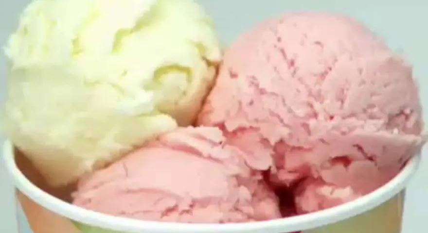 Drei Kugeln Eis in einem Becher: eine hellgelbe und zwei rosafarbene. Verschiedene eis arten für süße Momente.