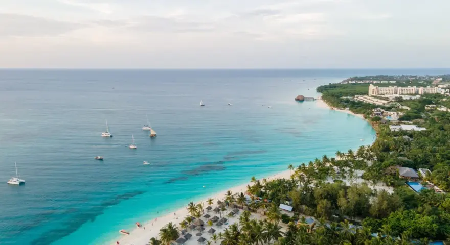 Rajska plaża na Zanzibarze z turkusową wodą, łodziami i luksusowymi hotelami. Sprawdź Zanzibar ceny i zaplanuj wymarzone wakacje!