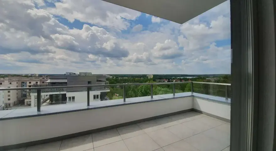 Przestronna loggia z widokiem na miasto i zieleń. Idealne miejsce na poranną kawę.