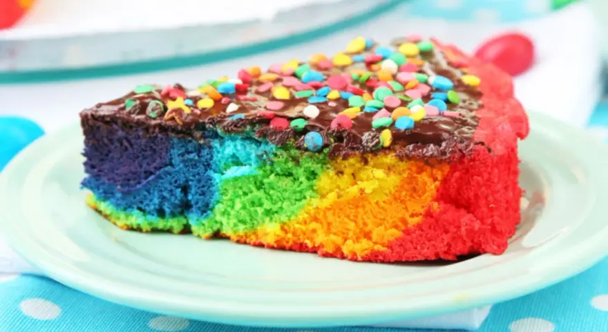 Buntes Kuchenstück mit Schokoladenglasur und Streuseln, perfekt für ein Papageienkuchen Rezept.