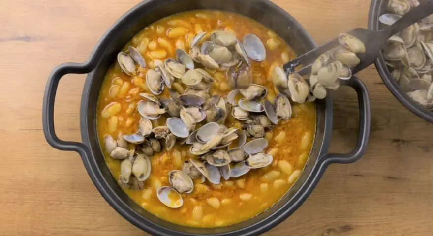 Plato humeante de fabes con almejas, un manjar tradicional.