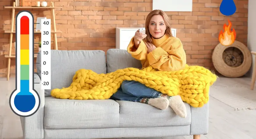 Donna sul divano con coperta gialla, termometro e icone di acqua e fuoco. Soluzione per deumidificare e riscaldare contemporaneamente.