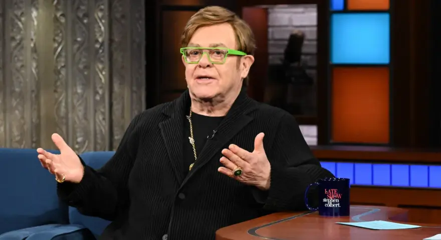 Elton John w zielonych okularach, z bogatym majątkiem, opowiada w programie.