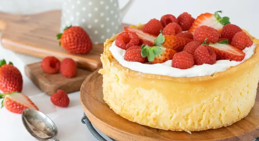 Deliciosa tarta de queso mascarpone y filadelfia, coronada con fresas y frambuesas frescas.