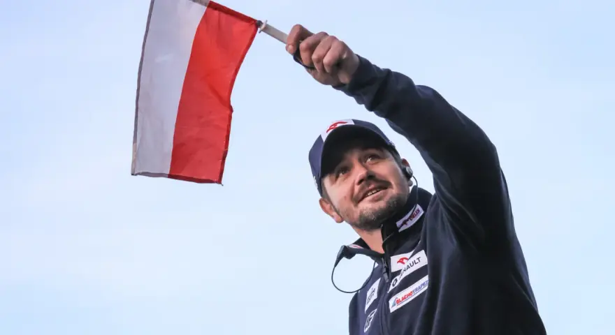 Radosny kibic z polską flagą na skoki narciarskie mistrzostwa świata juniorów.