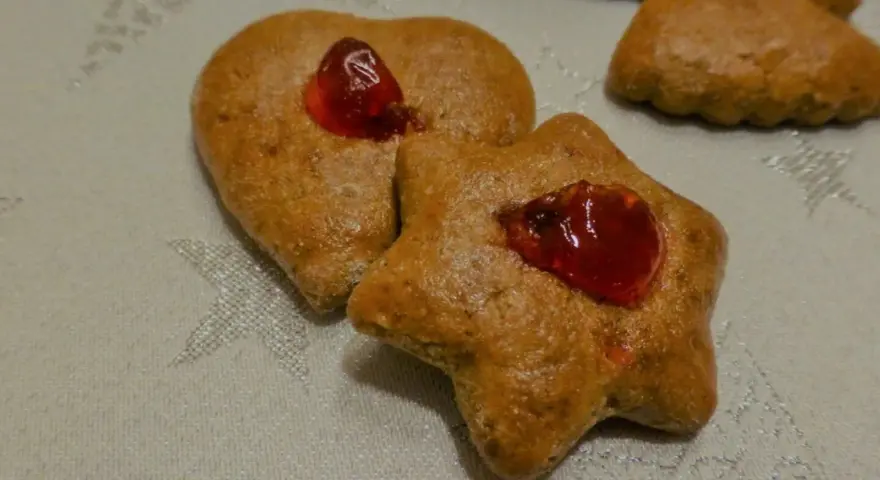 Herzförmige und sternförmige Lebkuchen mit roter Marmelade, die an alte Lebkuchen Rezepte erinnern.