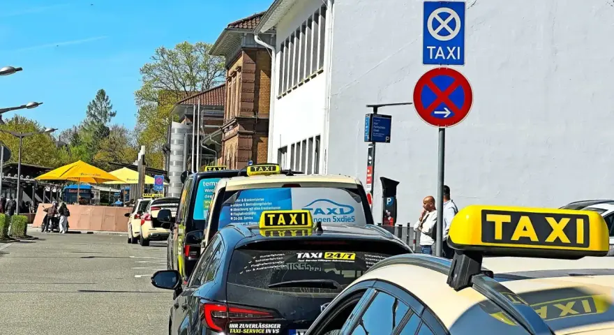 Taxistand mit Schildern. Was kostet eine Taxifahrt von 30 km? Die Schilder geben keine Auskunft über Preise.