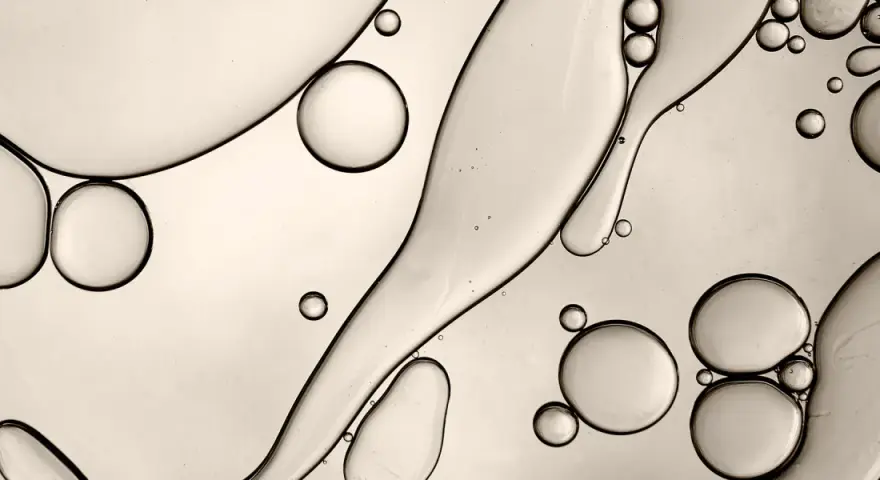 Gocce d'olio e acqua creano forme astratte, ricordando la struttura di un c13-15 alkane.