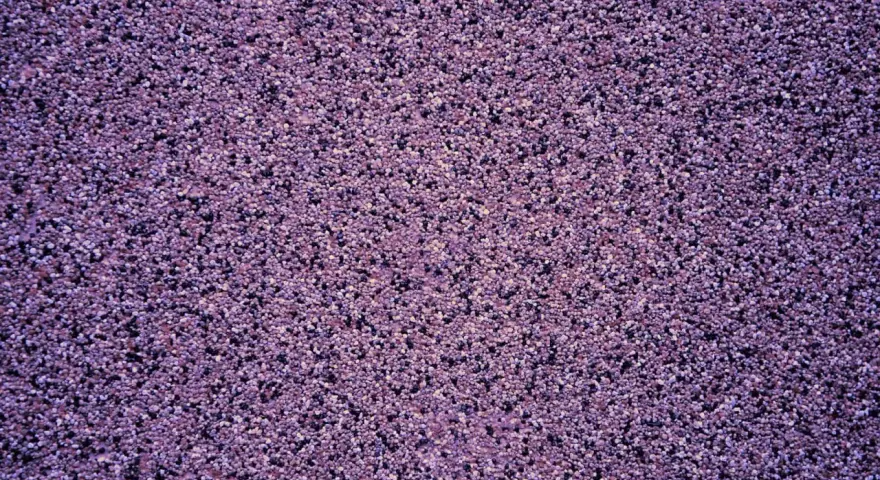 Fioletowy tynk mozaikowy o drobnej granulacji. Wydajność 25 kg na ok. 3-4 m², zależnie od grubości warstwy.