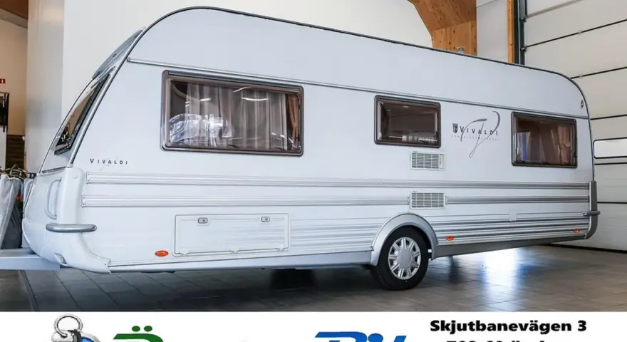 Vit husvagn, en av Tabbert modeller, står i ett garage.
