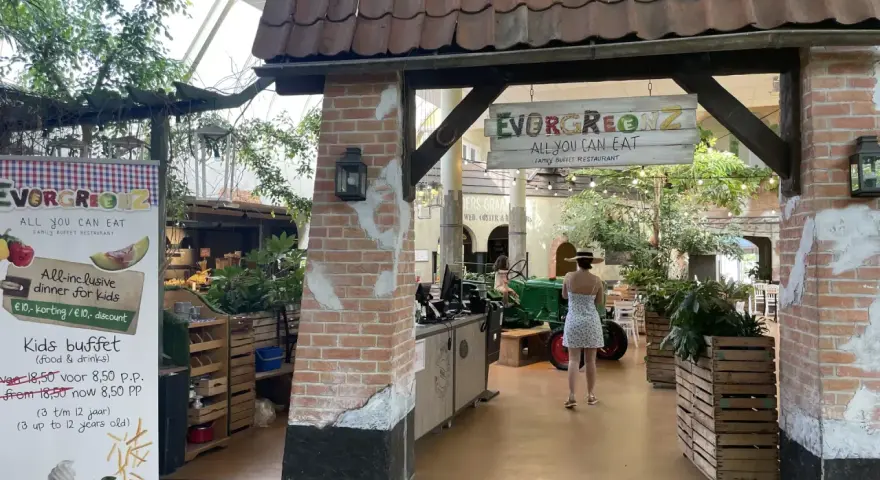Im Center Parcs Restaurant "Evergreenz" lockt ein Buffet. Eine Frau im Sommerkleid geht vorbei.