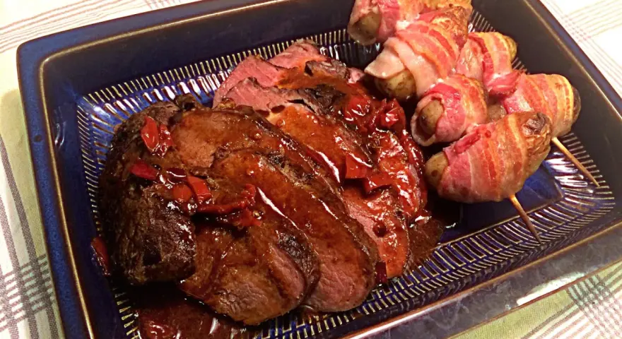 Helstekt entrecote i ugn, saftig och skivad, serveras med potatispaket inslagna i bacon. En festmåltid!