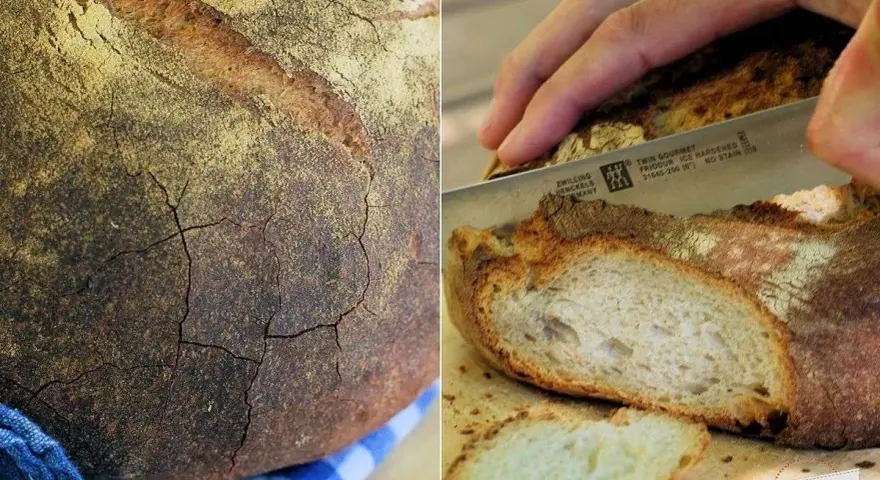 Krosses Brot mit Rissen, perfekt gebacken bei richtiger Temperatur. Ein Messer schneidet eine Scheibe ab.