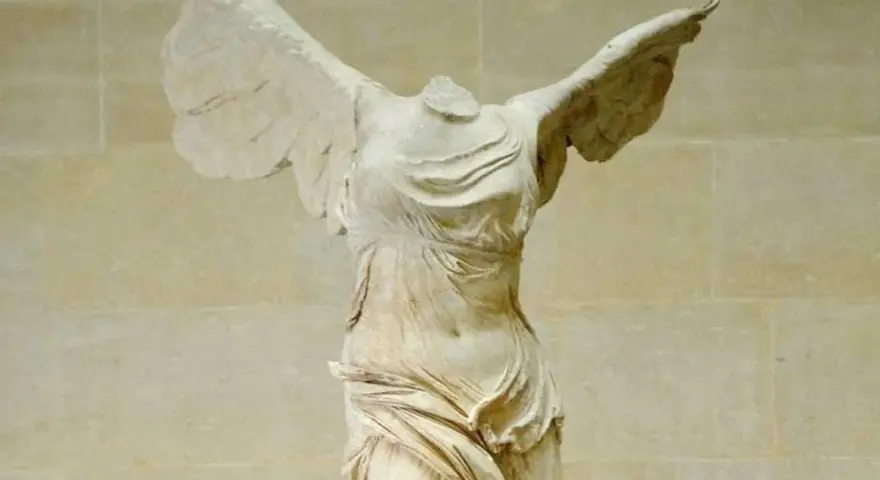 La Victoire de Samothrace, statue grecque antique sans tête, ailes déployées, drapé flottant.
