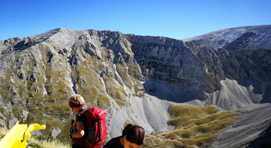 Escursionisti con zaini rossi ammirano il panorama montuoso vicino al bivacco Fusco.