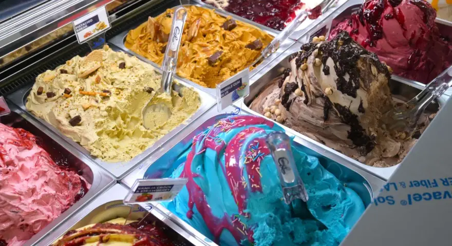 Verschiedene Sorten Eis: Pistazie, Karamell, Beeren, Schoko-Nuss und ein blaues Eis mit bunten Streuseln. Ein Fest für die Sinne!