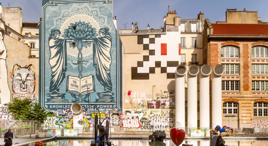 Un Space Invader pixelisé veille sur Paris, aux côtés d'une fresque monumentale et d'un cœur rouge dans un bassin.