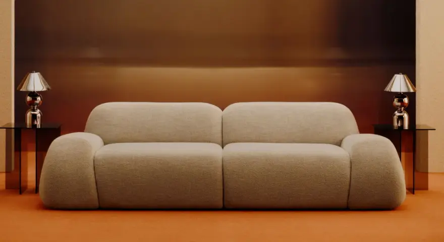 Divano beige bouclé, un materiale morbido e accogliente, con tavolini neri e lampade cromate.