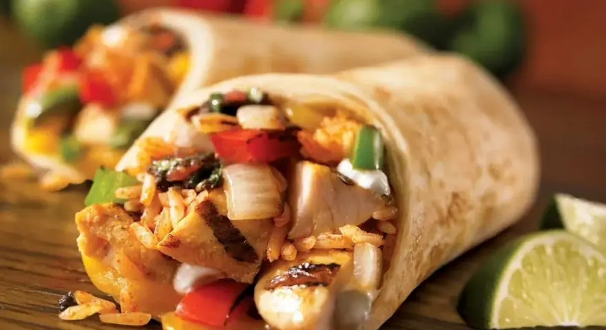 Pyszna tortilla z kurczakiem na ciepło, ryżem, warzywami i serem. Idealna na szybki posiłek.