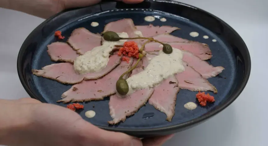 Vitello Tonnato: hauchdünne Scheiben Kalbfleisch, belegt mit cremiger Thunfischsauce, Kapern und roten Kaviar-Kügelchen.
