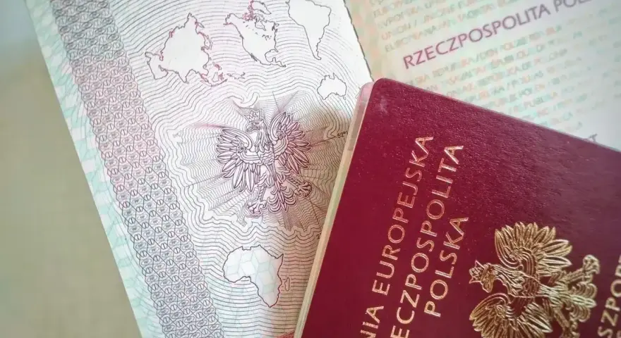 Polski paszport z godłem orła i mapą świata. Czy do Szwecji potrzebny jest paszport? Tak, jeśli podróżujesz spoza strefy Schengen.
