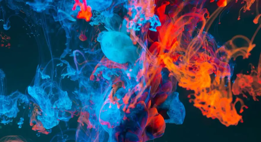 Nuvole di inchiostro blu e arancione si fondono in un vortice dinamico, evocando la potenza del colore nel cinema.