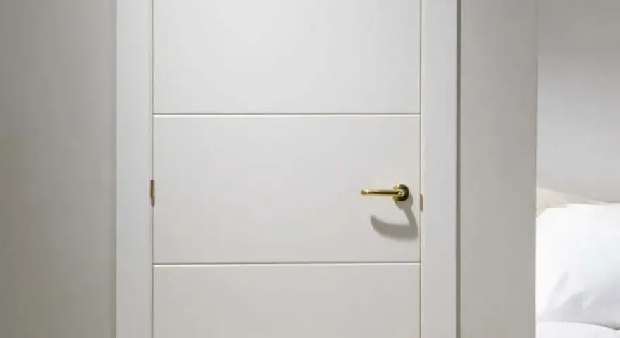 Puerta lacada en blanco con tirador dorado. Aprende como limpiar puertas lacadas en blanco para mantenerlas impecables.