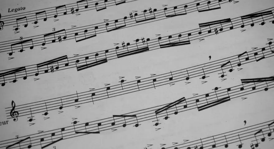 Muzyczne znaki na pięciolinii, nuty i akcenty tworzą melodię.