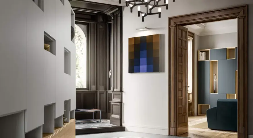 Ingresso di ville liberty moderne con arredi minimalisti, un quadro astratto e un lampadario scenografico.