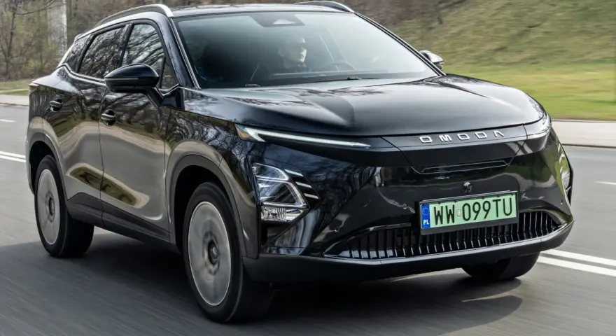 Czarny OMODA elektryk w ruchu drogowym. Nowoczesny design z charakterystycznym pasem świateł LED i logo marki.