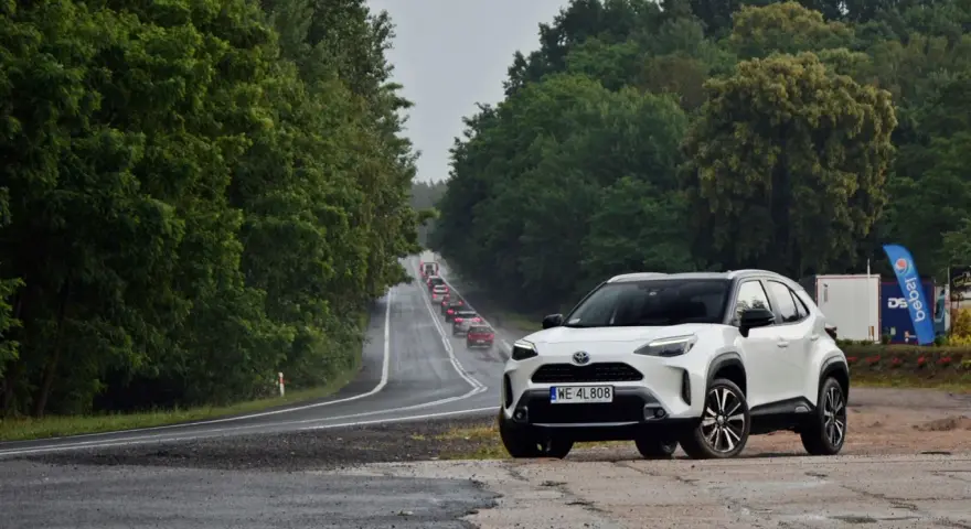 Biały crossover na poboczu drogi, w tle sznur samochodów i zielone drzewa. Trasa z Warszawy do Szczecina, ile km?