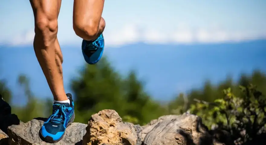 Nogi biegacza na kamienistym szlaku, przygotowującego się do ultramaratonu. Ile km jeszcze do mety?