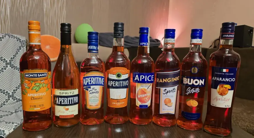 Rząd butelek aperitifów: Monte Santi, Aperitivo, Apice, Ranginio, Buon, Aparancio. Idealne na letnie wieczory, jak Martini Fiero a Aperol.