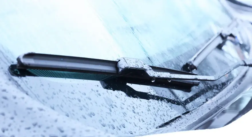 Scheibenwischer mit Wassertropfen. Die Scheibenwaschanlage funktioniert nicht. Woran kann das liegen? Vielleicht ist die Düse verstopft oder die Pumpe defekt.