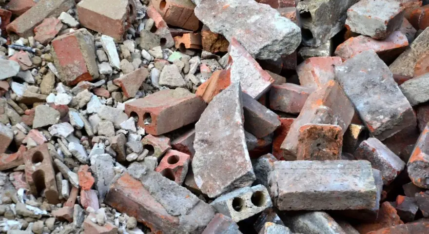 Stos gruzu budowlanego, cegieł i betonowych fragmentów. To materiał, który może być zaklasyfikowany jako gruz kod odpadu.