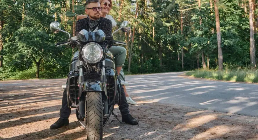 Para wyrusza na motocyklu przez las, marząc o podróży przez Karpaty i Sudety.