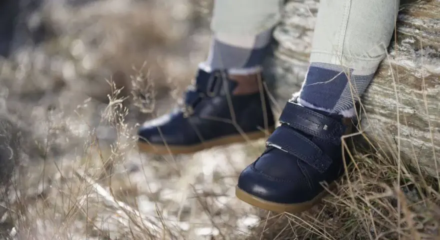 Granatowe, zimowe buty dziecięce na rzepy i sznurowadła, z futerkiem w środku. Wygodne i stylowe, idealne na jesienne i zimowe przygody. Różne marki butów oferują podobne modele.