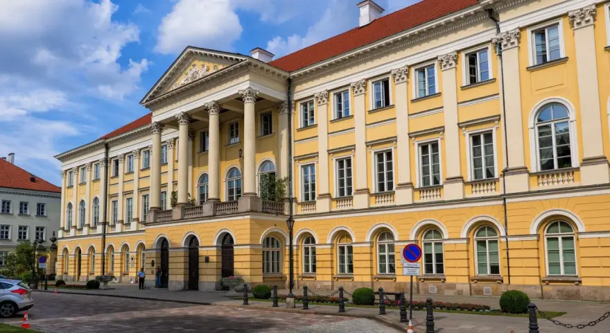 Imponujący żółty budynek z kolumnami, symbol jednych z najlepszych uczelni w Polsce.