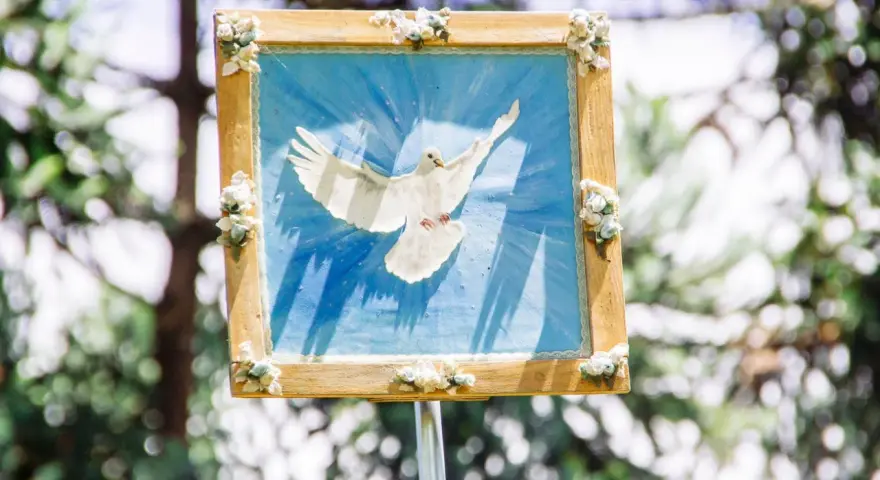 Ein Bild einer weißen Taube vor blauem Hintergrund, das den Heiligen Geist symbolisiert. Perfekt für einen Gottesdienst zu Pfingsten.