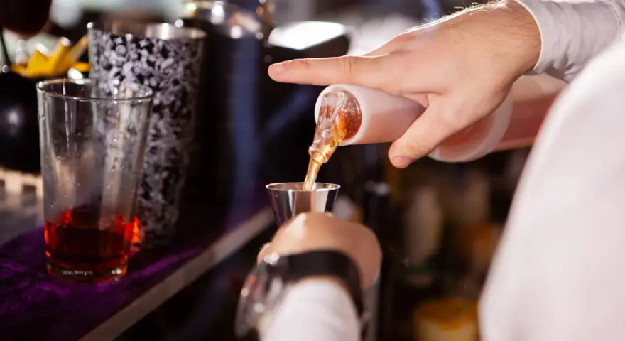 Barman w Toruniu precyzyjnie nalewa alkohol. Zastanawiasz się, ile zarabia barman w Toruniu?